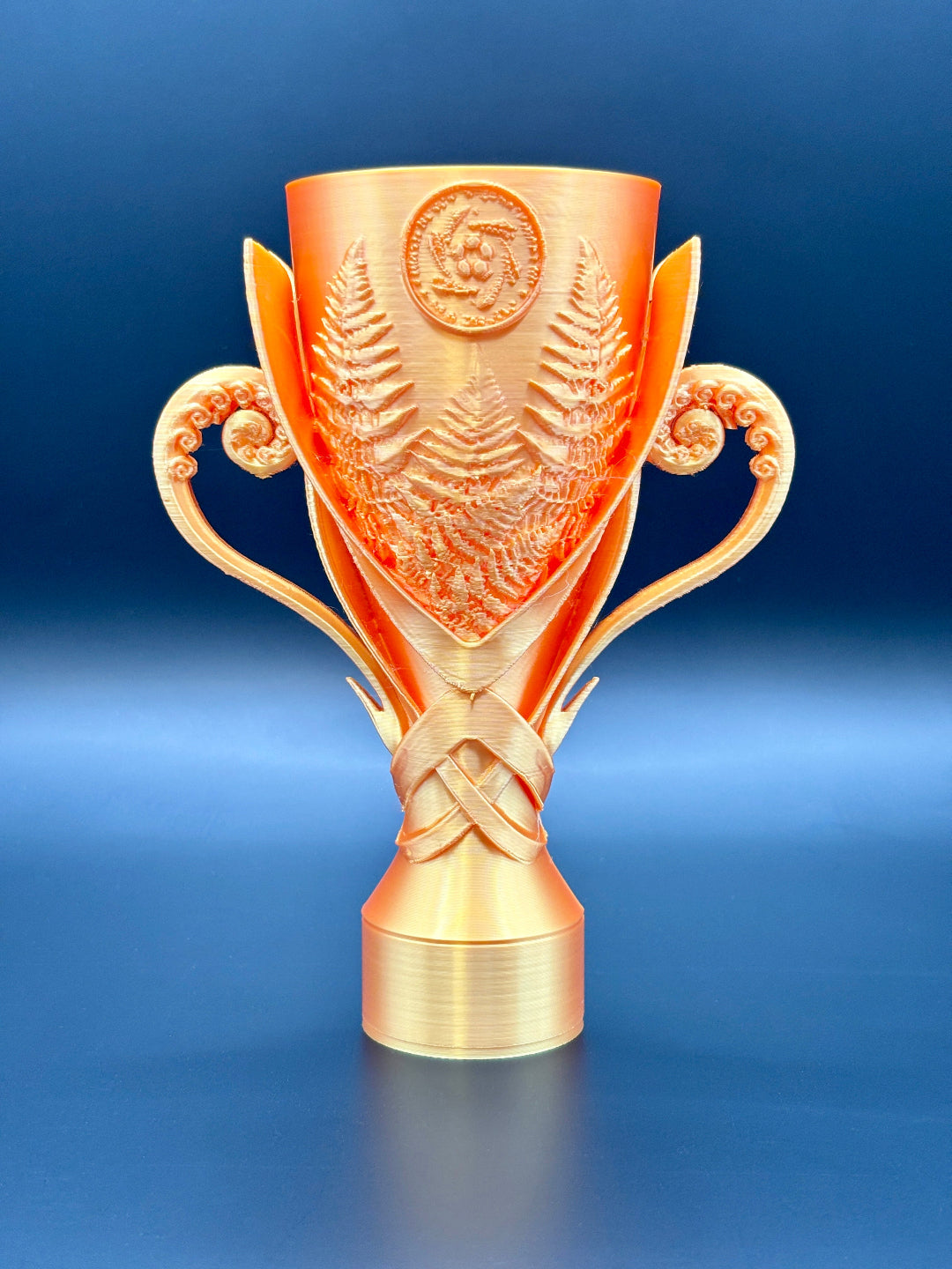 Gold CIC trophy with intricate design on a blue background
