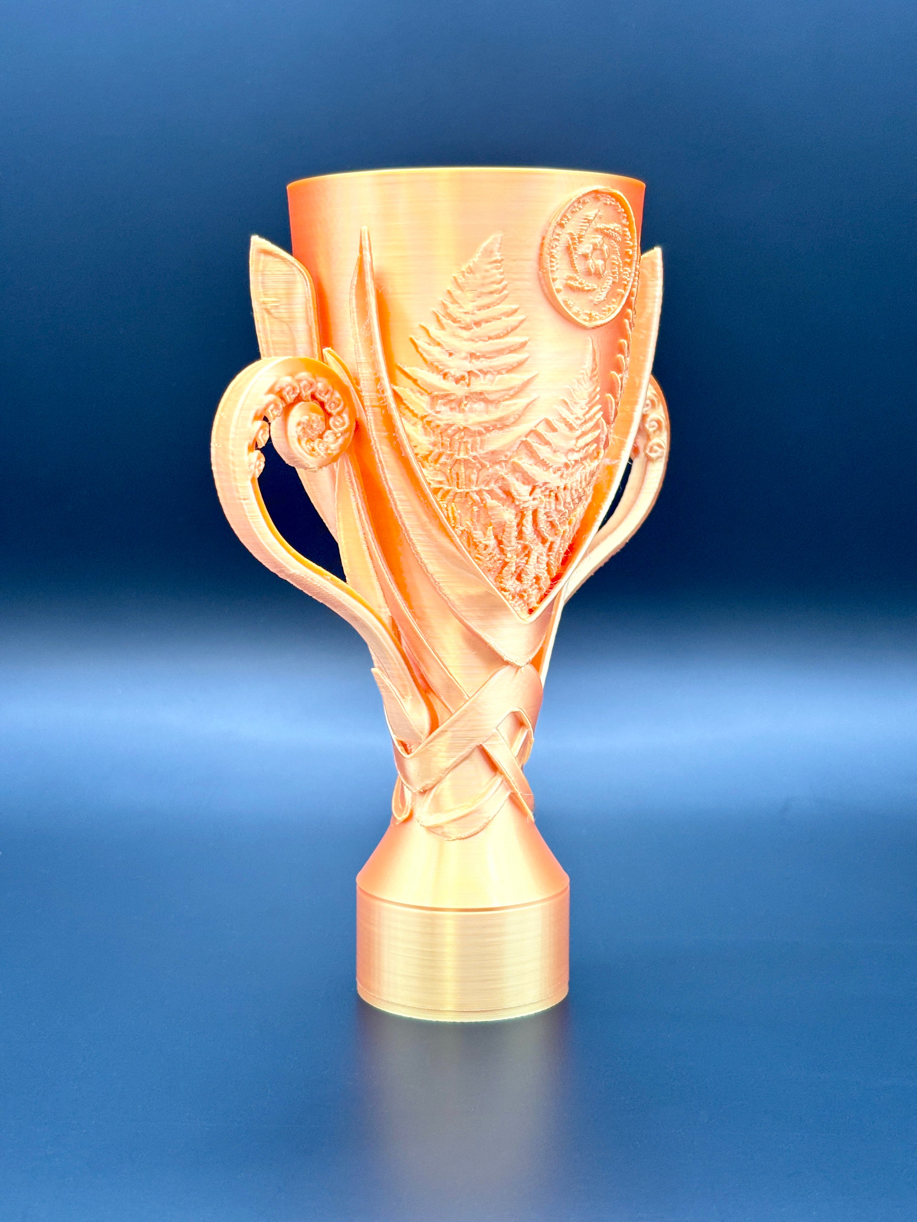 Gold CIC trophy with intricate design on a blue background